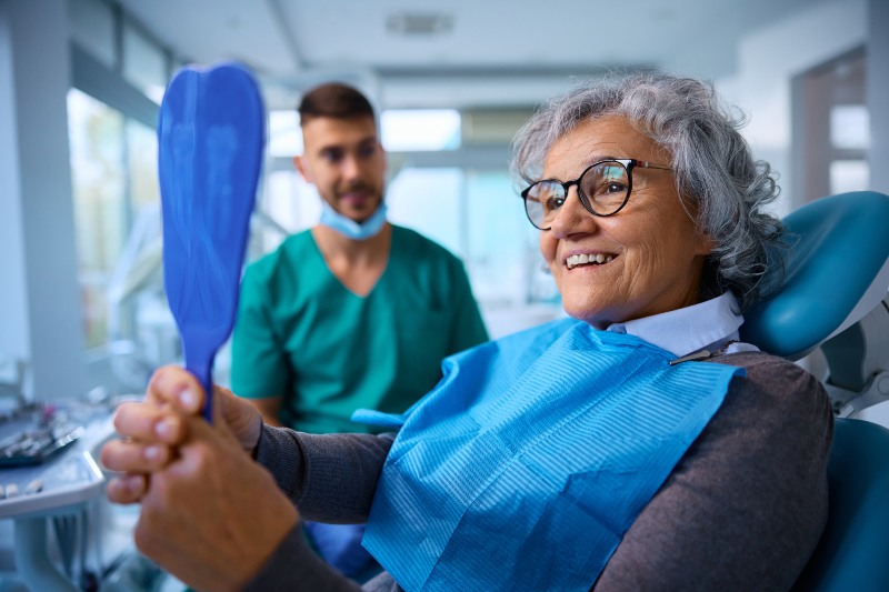 Smiling senior woman happy with her custom-crafted dentures in Kalamazoo, MI