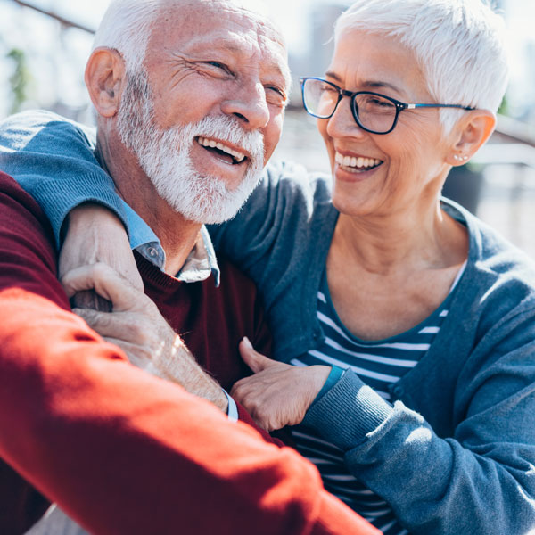 Laughing senior couple smiling after a dental implant procedure in Kalamazoo, MI