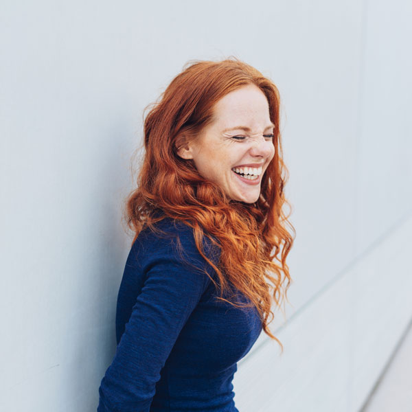 A female standing & smiling as she is happy with the results of cosmetic treatment in Kalamazoo